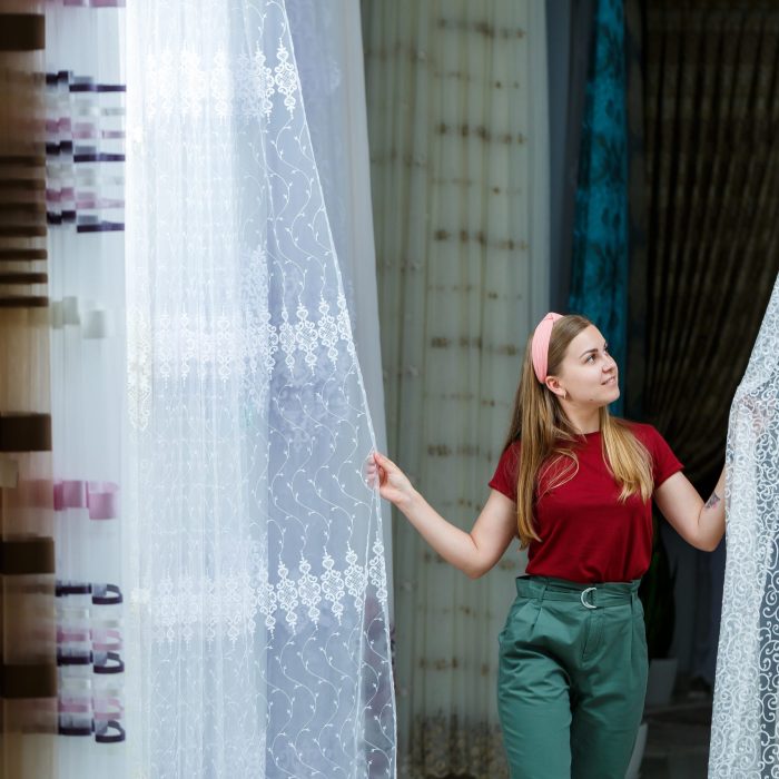 Young,Woman,Choosing,Fabric,For,New,Curtains,In,A,Store.